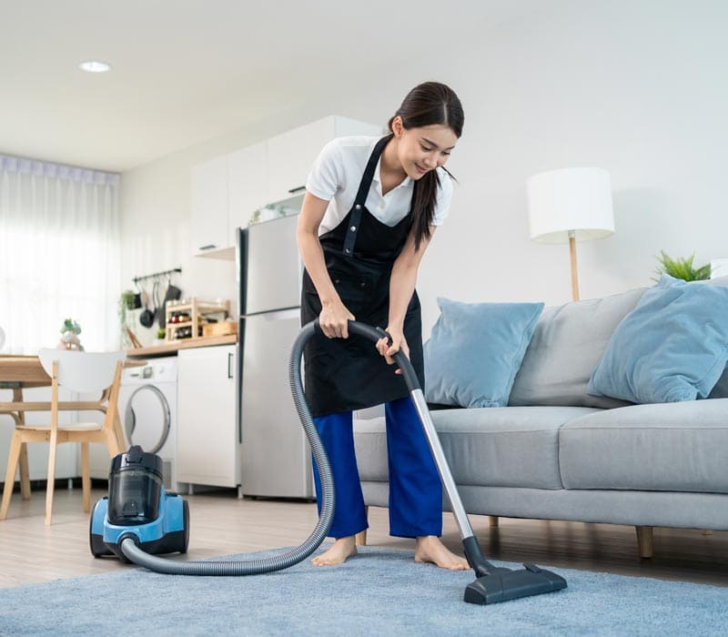 Professional cleaner vacuuming a living room in Austin, Denver or Seattle — expert apartment and home cleaning services with eco-friendly products by Gleaming Space.