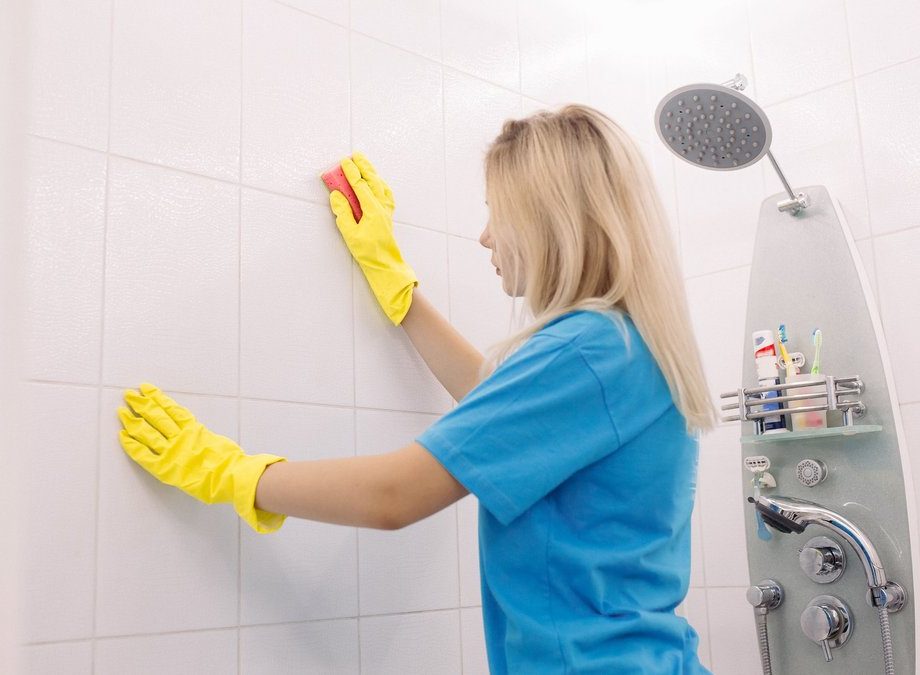 Professional bathroom cleaner sanitizing tile grout and shower walls in Austin – eco-friendly products for mold-free, allergen-safe spaces