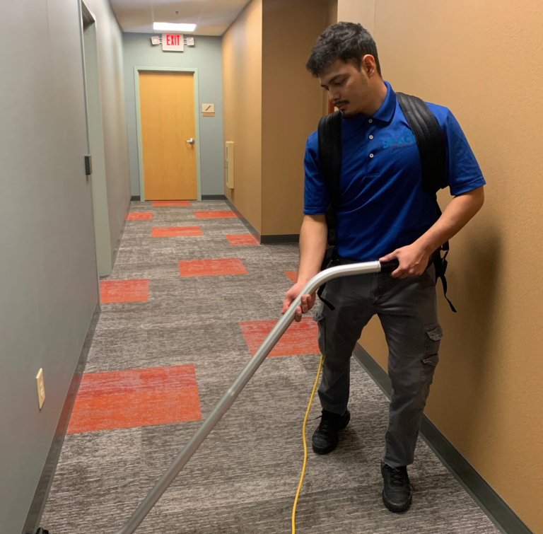 Professional commercial cleaning in Austin: licensed cleaner using HEPA vacuum for carpet and hallway deep cleaning — eco-friendly, recurring service for offices & businesses.