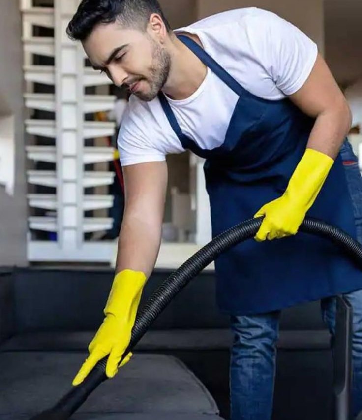 Professional cleaner in Austin performing deep sofa vacuuming with HEPA-filtered equipment — eco-friendly, pet-safe upholstery cleaning for apartments and homes.