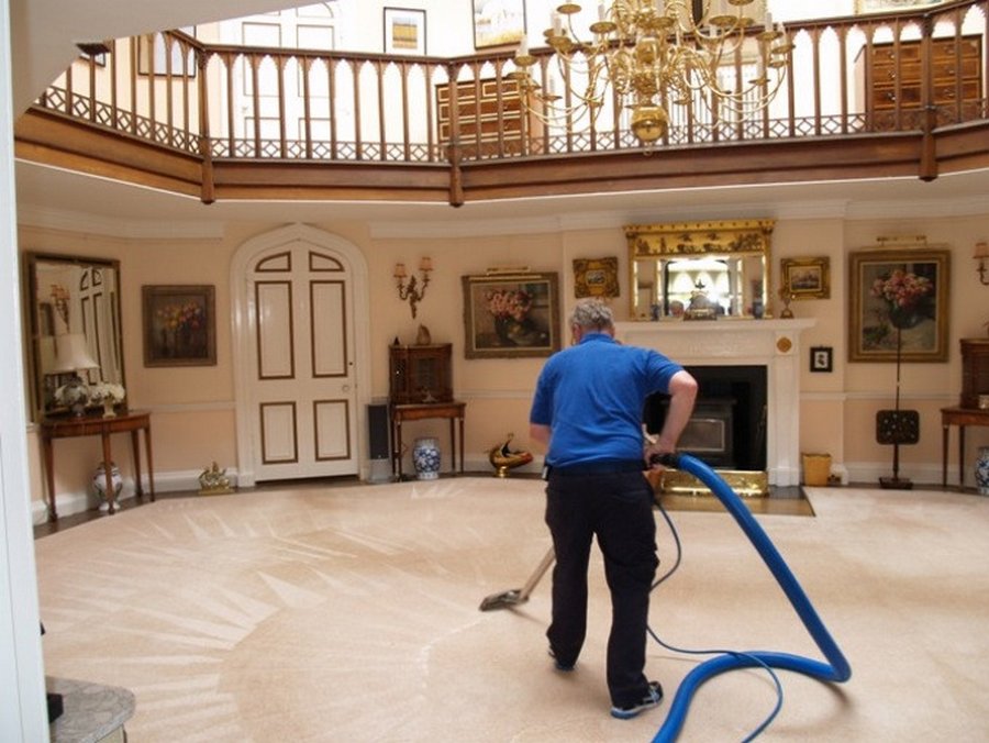 Professional cleaner using a commercial-grade vacuum on hardwood floors during a deep cleaning service in a historic Lakewood home. Our residential cleaning includes thorough dusting, baseboard cleaning, and furniture detailing for luxury homes across the Denver area.
