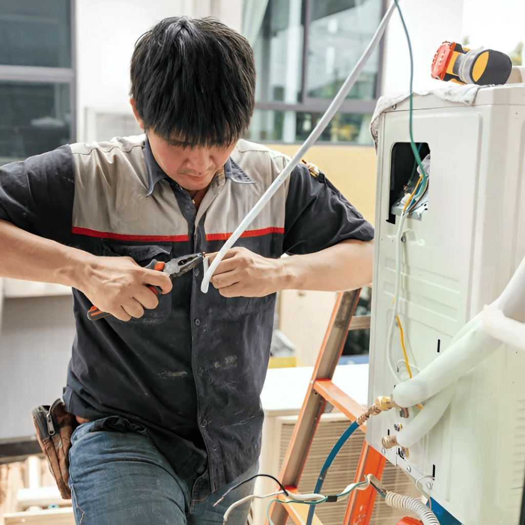 Professional HVAC technician performing electrical connections inspection and maintenance on outdoor air conditioning unit with calibrated tools in Colorado, Texas, and Washington