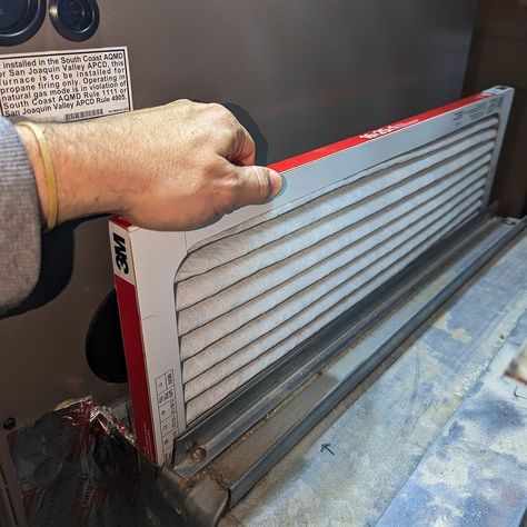 Professional indoor air quality (IAQ) solutions by Gleaming Space, showing a technician replacing a clean air filter as part of a whole-house air duct cleaning service in CO, TX, and WA.