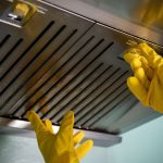 Professional kitchen hood and exhaust cleaning service by Gleaming Space, showing grease removal from a commercial vent hood for fire safety and improved air quality in TX, CO, and WA.