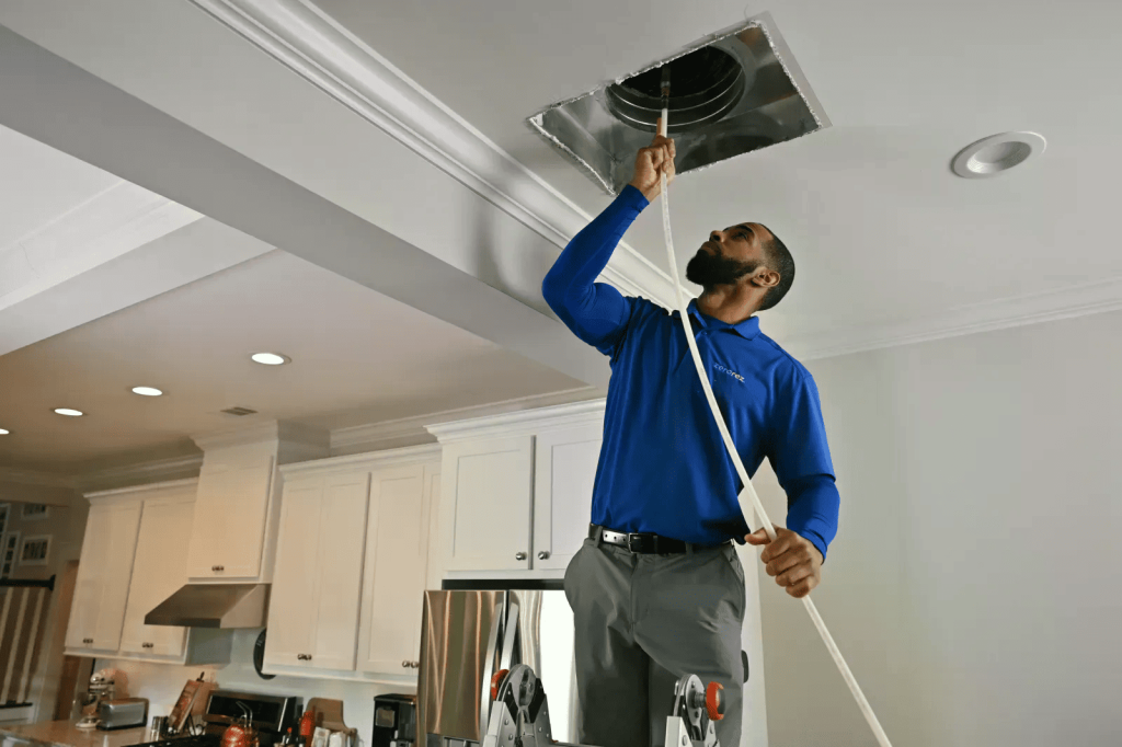 Professional technician performing air duct cleaning and hvac vent cleaning as part of a full system furnace cleaning service in CO, TX, and WA.
