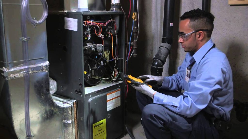 Skilled HVAC technician conducting thorough furnace inspection and cleaning service in residential home