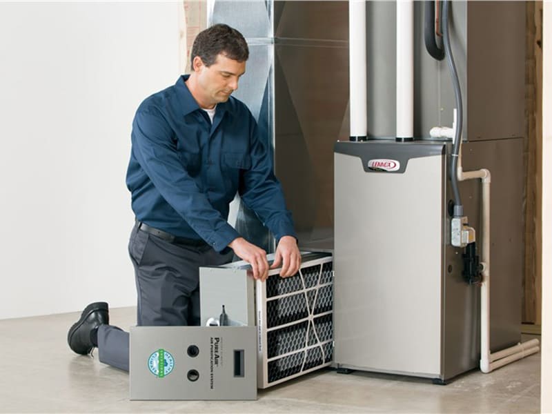 Certified technician servicing furnace components during complete system inspection and maintenance call